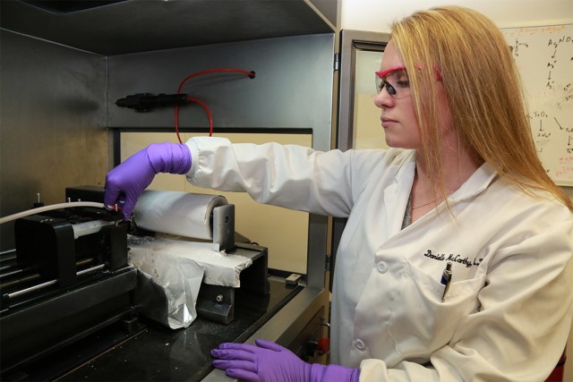 Center research chemist Danielle Kuhn uses an electrospinning unit to create polymer nanofibers containing BioCNFs.