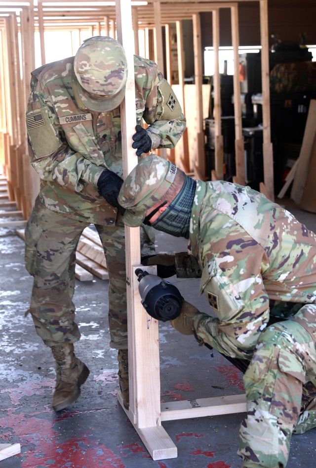 Cpl. Donovan Taylor (right) and Spc. Matthew Cummins (left), combat engineers with Alpha Company, 52nd Brigade Engineer Battalion, 2nd Infantry Brigade Combat Team, 4th Infantry Division assemble a frame for a partition April 9 at Fort Carson, Colorado. The completed partitions are to be installed at Centennial Regional Training Institute to provide safety and privacy for Soldiers in isolation. (U.S. Army photo by Sgt. Gabrielle Weaver)