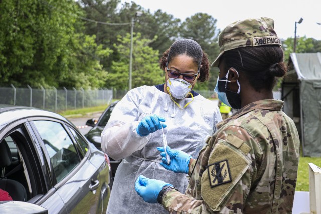 A Georgia Army National Guardsman from the Decatur-based 170th Military Police Battalion assists the Dekalb Fire Department in testing for coronavirus at a specimen point of collection (SPOC) site in Decatur, Ga., on April 24, 2020. SPOC sites...