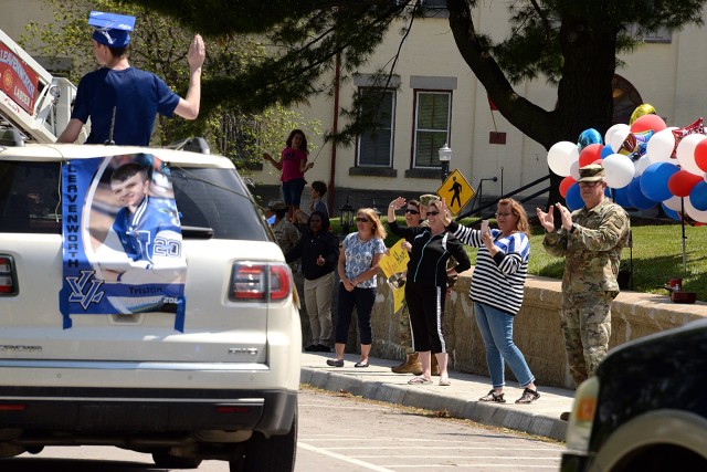 Leavenworth High School senior Tristan Smith waves at graduation parade spectators, including Combined Arms Center and Fort Leavenworth Commanding General Lt. Gen. James Rainey and his wife Tracy, as the parade passes the Rainey residence May 15...
