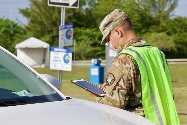 A Soldier from the 144th Transportation Company out of Marianna, Fla. conducts patient scribing at Amelia Earhart Park CBTS. They have worked at the CBTS as traffic control, scribers, assisting nurses with the test procedure and reporting relevant numbers to the appropriate authorities. (US Army photo by Sgt. Leia Tascarini)