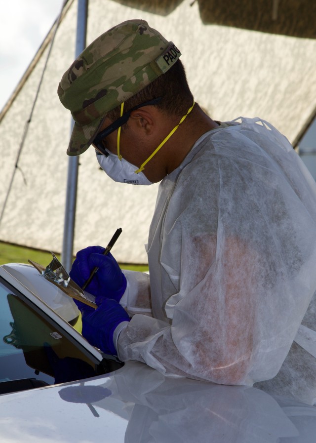 A Soldier from the 144th Transportation Company out of Marianna, Fla. conducts patient scribing at Amelia Earhart Park CBTS. They have worked at the CBTS as traffic control, scribers, assisting nurses with the test procedure and reporting relevant numbers to the appropriate authorities. (US Army photo by Sgt. Leia Tascarini)