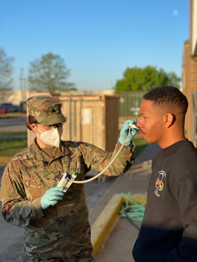 Sgt. Kerianna Turner, left, and Cpl. Jonah Pollard, Headquarters and Headquarters Company, 2nd Battalion, 327th Infantry Regiment “No Slack”, 1st Brigade Combat Team “Bastogne”, 101st Airborne Division (Air Assault), rehearse COVID-19 screening procedures with a temperature check on Fort Campbell, Ky., April 10. Medics rehearse screening procedures for COVID-19 to maintain their readiness and ensure the safety and welfare of Soldiers and their families. (U.S. Army photo by 1st. Lt. Jake Verdi)