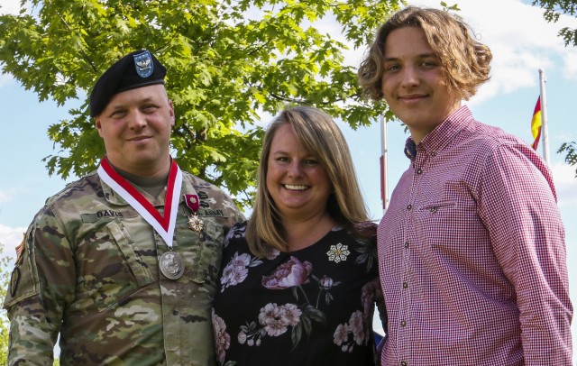 Col. Timothy Davis, senior operations advisor, 7th Army Training Command, poses for a picture with his wife and son after being awarded the Legion of Merit during the Service with Honor ceremony in Grafenwoehr, Germany, May 21, 2020. The Service with Honor ceremony, hosted by Brig. Gen. Christopher Norrie, commanding general, 7th ATC, was held to recognize senior leaders for their hard work and dedication while assigned to 7th ATC. (U.S. army photo by Spc. Zack Stahlberg)