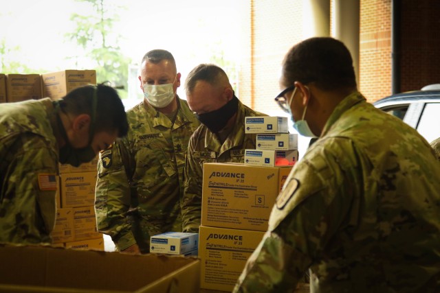 North Carolina Army National Guard Soldiers sort and count boxes of Personal Protective Equipment while working alongside North Carolina Emergency Management during a PPE distribution in Central N.C., May 19, 2020. The NCNG is working with NCEM, N.C. Department of Health and Human Services and local food banks to help support COVID-19 relief efforts. (U.S. Army National Guard photo by Spc. Hannah Tarkelly, 382nd Public Affairs Detachment/Released).