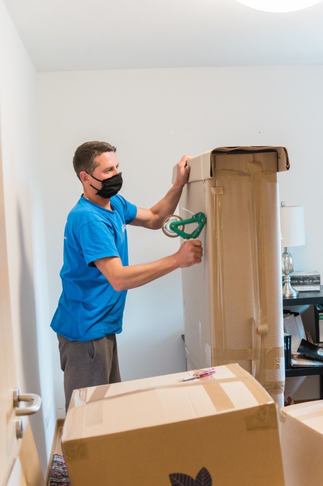 WIESBADEN, Germany - A mover tapes up a box at an apartment at U.S. Army Garrison Wiesbaden May 22 while following health protocols. The Department of Defense has directed that moving personnel adhere to Centers for Disease Control and Prevention...