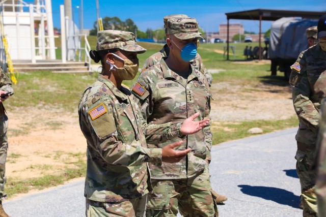 Capt. Megan Bridges, commander of C Company, 1st Battalion (Airborne), 507th Parachute Infantry Regiment, briefs Gen. Paul E. Funk, commanding general of Training and Doctrine Command, on the COVID-19 mitigation measures used to keep Airborne...