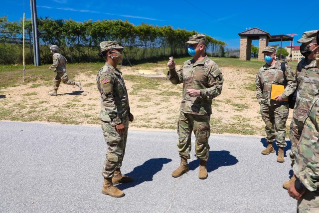 Gen. Paul E. Funk, commanding general of Training and Doctrine Command, presents a coin to Capt. Megan Bridges, a chemical officer who commands an Airborne training company, after she briefed him on the COVID-19 mitigation measures used to keep...