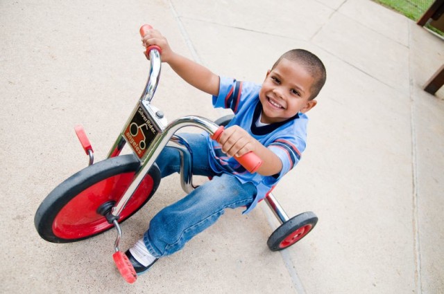 A young boy plays on a tricycle (U.S. Army photo)