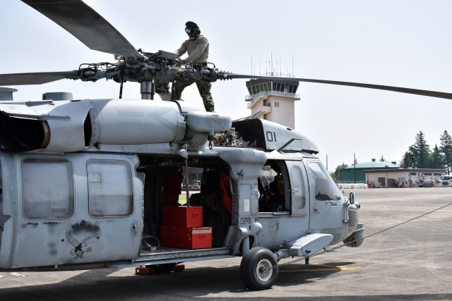 Navy Petty Officer 2nd Class Abrahanjakou Gudino Boscan, assigned to the Helicopter Sea Combat Squadron 25, Detachment 6, the “Archangels,” works on a Navy MH-60S Sea Hawk helicopter at Kastner Army Heliport, Camp Zama, Japan, May 13.