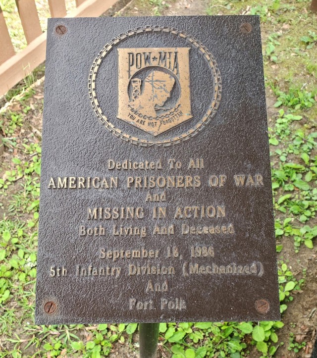 Pictured is a Prisoner of War/ Missing in Action plaque dedicated to "All American Prisoners of War and Missing in Action." The plaque was dedicated by the 5th Infantry Division and Fort Polk on Sept. 18, 1986; it is located within a gazebo near...