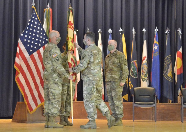 Command Sergeant Major Jason W. Osborne, outgoing U.S. Army Garrison-Fort Campbell senior enlisted leader, passes on the garrison colors to Command Sgt. Maj. Joseph Harbour, incoming garrison senior enlisted leader, May 28, during a change of responsibility ceremony at Wilson Theater, Fort Campbell. Col. Jeremy E. Bell, garrison commander, led the ceremony.  