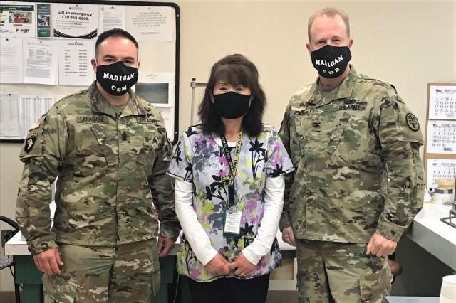 (U.S. Army photo) Madigan Seamstress Hwan Peveto is flanked by Command Sgt. Maj. Victor Laragione and Commander Col. Thomas Bundt as they pay her a visit on May 21, to thank her for her initiative in creating face coverings to aid staff members in meeting the requirement that they wear them on the Madigan campus in public areas and when not able to distance properly. 