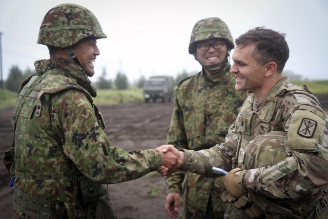 U.S. Army Lt. Col. Timothy Lynch, right, assigned to the 17th Field Artillery Brigade, which is conducting the Multi-Domain Task Force pilot, shakes hands with the battalion commander of Western Army Field Artillery of the Japan Ground Self-Defense Force during the Orient Shield exercise at Yausubetsu Training Area, Japan, Sept. 16, 2019.