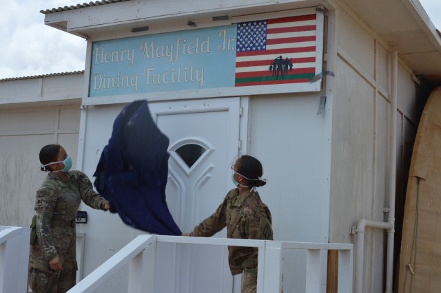 U.S. Army soldiers prepare to unveil the Henry Mayfield Jr. Dining Facility during the building’s grand opening and dedication ceremony at Baledogle Military Airfield (BMA), Somalia, May 1, 2020. The facility was named for U.S. Army Spc. Henry J. “Mitch” Mayfield Jr., who was killed in action Jan. 5, 2020, during an attack on Manda Bay Airfield, Kenya, by a terrorist organization. Mayfield, a Chicago native, was deployed to Kenya with the 1st Battalion, 58th Aviation Regiment, 164th Theater Airfield Operations Group, from Fort Rucker, Alabama. (U.S. Navy photo by Logistics Specialist 2nd Class Toniece Lurch)