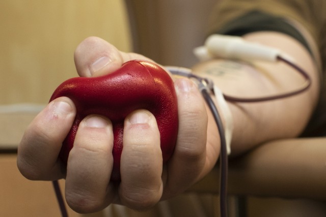 Navy Airman Recruit Matthew Thompson, an aviation ordnanceman assigned to USS Gerald R. Ford's weapons department, squeezes a stress ball while donating blood during an Armed Services Blood Program drive at Huntington Hall in Newport News,...