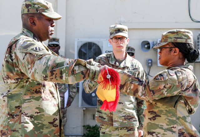 Lt. Col. Eric Brooks, left, and Master Sgt. Rachel Harris prepare to case the organizational colors of the 919th Contracting Battalion during a ceremony May 22 as the unit prepares to return home to Fort Bliss, Texas. Brooks is the 919th CBN commander and Harris is the battalion senior enlisted adviser.