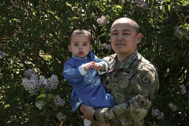 U.S. Army Capt. Vinh T. Nguyen, military police officer, assigned to the 2d Cavalry Regiment, poses with son after discussing significant aspects of  Vietnamese culture in honor of Asian American and Pacific Islander Heritage Month in Vilseck, Germany, May 18, 2020. Nguyen shared the historical background and present-day traditions of the ao dai. (U.S. Army photo by Sgt. LaShic Patterson)