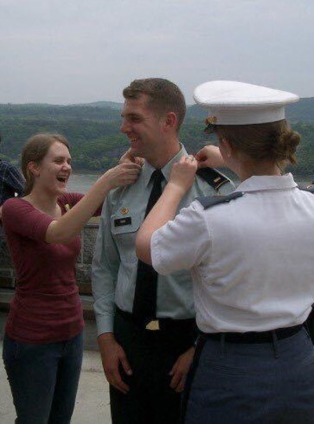 Then 2nd Lt. Nicholas Fiore smiles in celebration as his sisters Carolyn Fiore, left, and Elyse Pierre, right, affix his shoulder boards displaying his rank to his uniform shortly after receiving his commission as an armor officer in 2007. Each of...