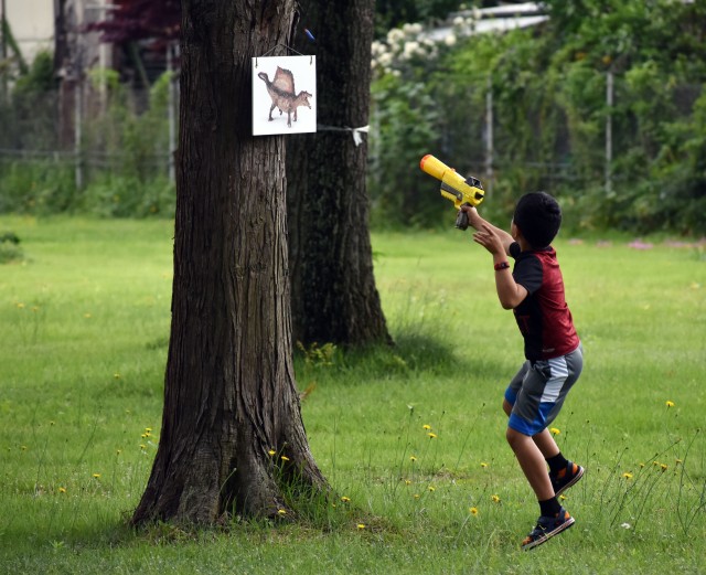 Nahum Giron, 7, hits a dinosaur target with his Nerf gun while participating in the Jurassic SHA Nerf Dinosaur Hunt at the Sagamihara Family Housing Area, Japan, June 2.