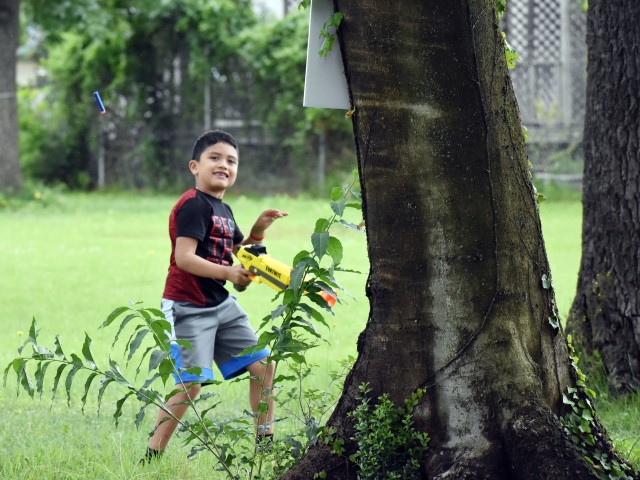 Nahum Giron, 7, smiles after hitting a dinosaur target with his Nerf gun while participating in the Jurassic SHA Nerf Dinosaur Hunt at the Sagamihara Family Housing Area, Japan, June 2.