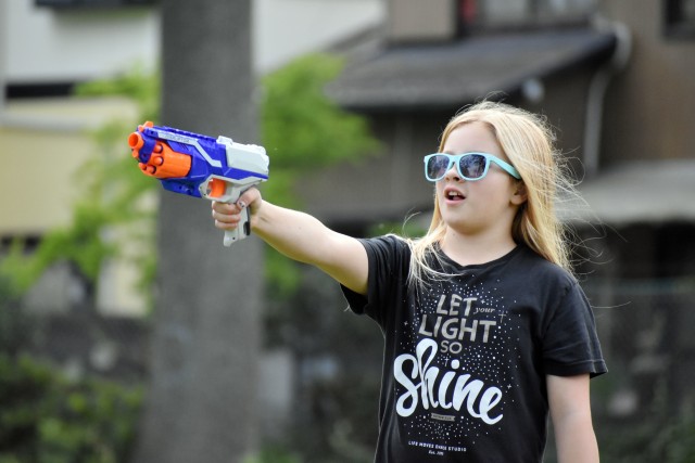 Rivers Prokopi, 11, takes aim at a dinosaur target with her toy dart gun while participating in the Jurassic SHA Nerf Dinosaur Hunt at the Sagamihara Family Housing Area, Japan, June 2.