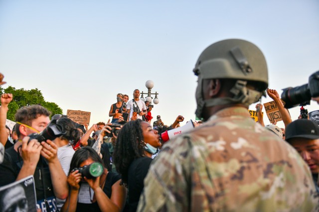 Minnesota National Guard Master Sgt. Acie Matthews Jr. peacefully engages with protesters to show solidarity and request compliance with the state curfew at the grounds of the Minnesota state capitol in St. Paul, June 1, 2020. The Minnesota Guard has activated troops to protect citizens and infrastructure as people protested on the steps of the capitol building. 