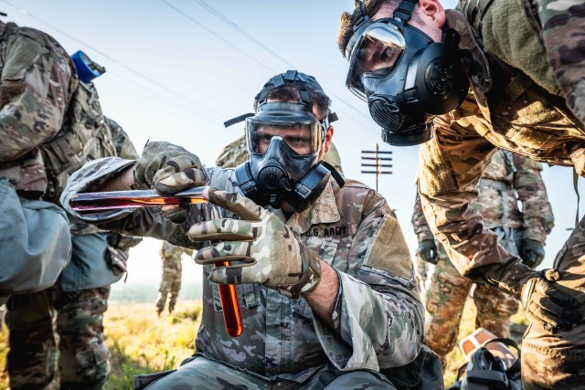 A Cerberus Battery, 5th Battalion, 5th Air Defense Artillery Soldier combines two vials of liquid to complete the last component of the physical training session May 29, 2020, on Medicine Bluffs at Fort Sill, Oklahoma. All Soldiers wore masks after a simulated gas attack was initiated.