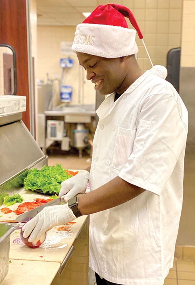 FORT CARSON, Colo. — Cpl. Devon Douglas, Fort Carson Better Opportunities for Single Soldiers (BOSS) president, prepares meals at a local dining facility Dec. 25, 2019. The BOSS program held a special dinner on Christmas Day for single Soldiers who had nowhere to celebrate the holidays. (Courtesy photo)