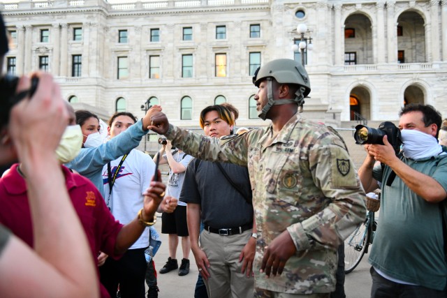 Minnesota National Guard Master Sgt. Acie Matthews Jr. peacefully engages with protesters to show solidarity and request compliance with the state curfew at the grounds of the Minnesota state capitol in St. Paul, June 1, 2020. The Minnesota Guard has activated troops to protect citizens and infrastructure as people protested on the steps of the capitol building. 