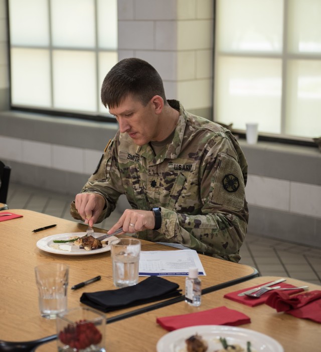 Lt. Col. Paul W. Smith, Commander, 61st Quartermaster Battalion, tastes an entree from one of the chefs June 5.  Culinary specialists from the 553rd Field Feeding Company, 61st Quartermaster Battalion, 13th Expeditionary Sustainment Command, held their first Iron Chef Competition at the Always Ready dining facility. (U.S. Army photo by Sgt. 1st Class Kelvin Ringold)