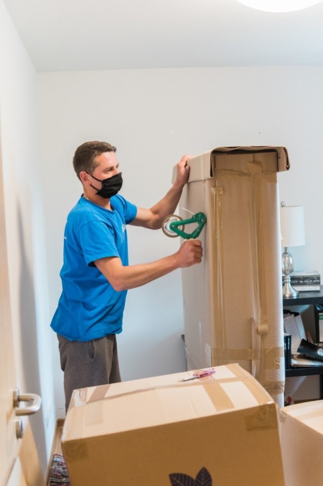 A mover tapes a box at an apartment at U.S. Army Garrison Wiesbaden May 22, 2020 while following health protocols. The Department of Defense has increased the monetary sum Soldiers will receive if they choose the personally-procured move option...