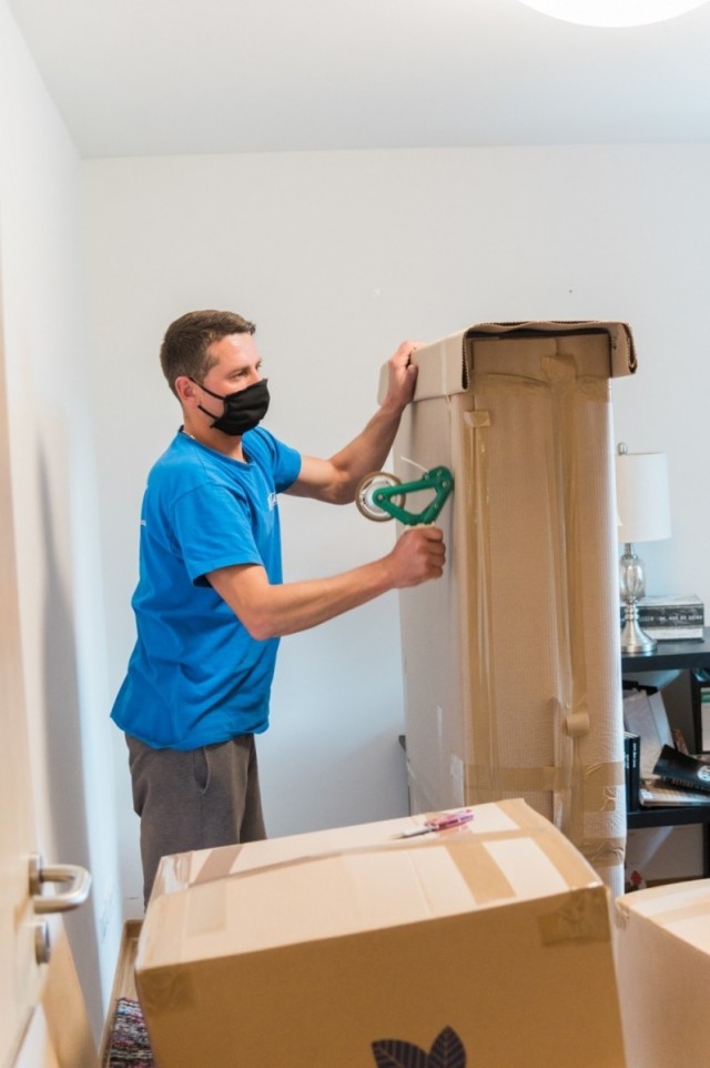 A mover tapes a box at an apartment at U.S. Army Garrison Wiesbaden May 22, 2020 while following health protocols. The Department of Defense has increased the monetary sum Soldiers will receive if they choose the personally-procured move option during PCS moves. 