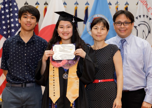 Hannah Santos, class salutatorian, poses for a photo with her family while holding her diploma during the Zama Middle High School virtual graduation June 3 at the school’s auditorium. The virtual ceremony was a necessity due to the ongoing...