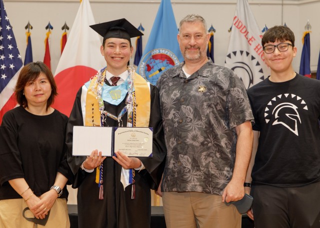 Milton Jones, class valedictorian, poses for a photo with his family while holding his diploma during the Zama Middle High School virtual graduation June 4 at the school’s auditorium. The virtual ceremony was a necessity due to the ongoing...