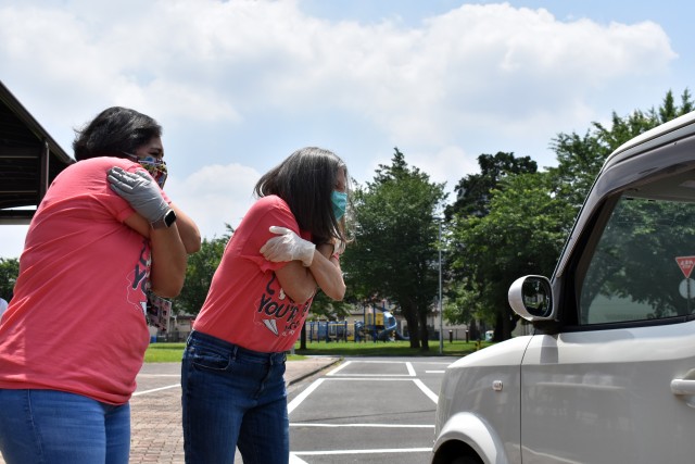 Fumi Marquez, right, a kindergarten teacher at John O. Arnn Elementary School, and Reynalda Espinoza, her classroom aide, send hugs to a student during an item exchange on the school’s last day at Sagamihara Family Housing Area, Japan, June 8.