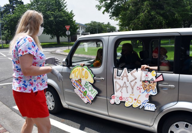 Kristi Ramsey, a math support specialist volunteering for the day at John O. Arnn Elementary School, approaches a decorated vehicle during an item exchange on the school’s last day at Sagamihara Family Housing Area, Japan, June 8.