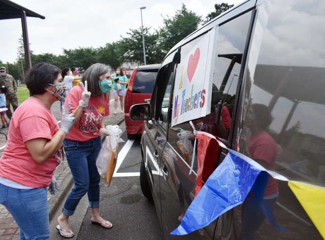 Fumi Marquez, right, a kindergarten teacher at John O. Arnn Elementary School, and Reynalda Espinoza, her classroom aide, greet a parent and student during an item exchange on the school’s last day at Sagamihara Family Housing Area, Japan, June 8.
