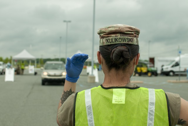 Spc. Anya Kulikowski, an MP Soldier with the Delaware Army National Guard’s 153rd Military Police Company, directs traffic during a drive-thru coronavirus testing mission at the University of Delaware&#39;s Science, Technology and Advanced Research Campus in Newark, Del., May 29, 2020. About 25 Soldiers and airmen with the Delaware National Guard supported the saliva-based testing of roughly 400 people at the STAR Campus location. 