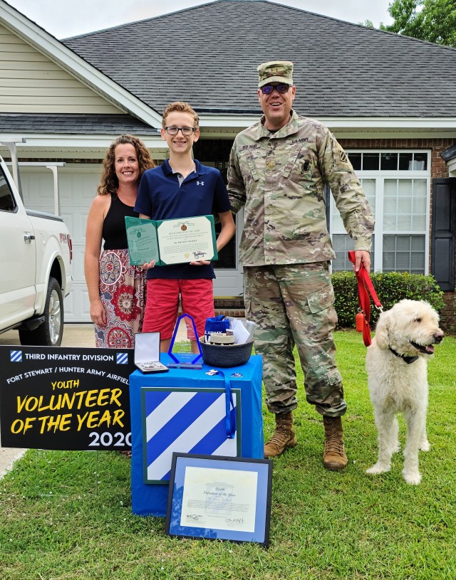 Preston Ver Hoef, the Fort Stewart Hunter Army Airfield’s 2020 youth volunteer of the year award winner poses with his Family while holding his public service commendation medal, June 4, 2020, at his residence in Richmond Hill, Georgia. “Batman” presented Ver Hoef the award for over 60 hours of community service through Richmond Hill Middle School by offering support to special needs students. (U.S. Army photo by Sgt. Arjenis Nunez)