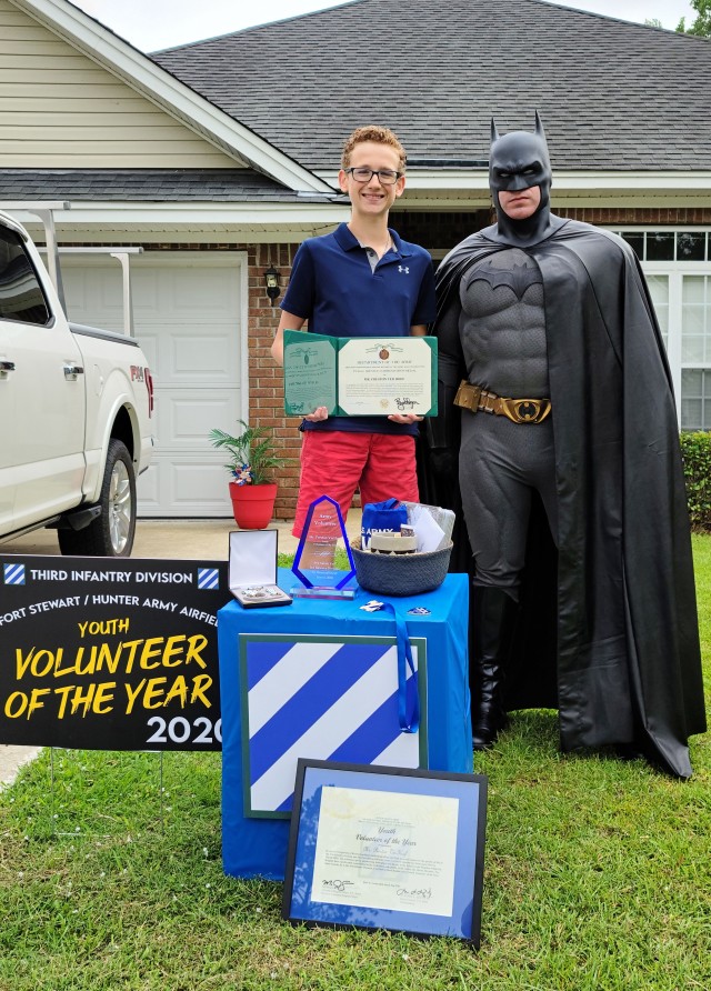 Preston Ver Hoef, the Fort Stewart Hunter Army Airfield’s 2020 youth volunteer of the year award winner poses with Sgt. Anthony Licata, a trumpet player assigned to the 3rd Infantry Division Band who is dressed as Batman, while holding his...