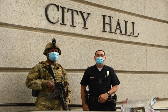 A Soldier from Bravo Company, 1st Battalion, 160th Infantry Regiment, poses for a photo with a Los Angeles Police Department officer on June 5, 2020 at Los Angeles City Hall. (U.S Army photo by Capt. Jason Sweeney, 79th Infantry Brigade Combat Team)