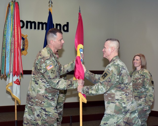 Col. Gavin J. Gardner, the new commander for the Joint Munitions Command, passes the JMC flag to Lt. Gen. Thomas S. James, Jr., while Brig. Gen. Michelle M.T. Letcher, the outgoing JMC commander looks on during a change of command ceremony held at...