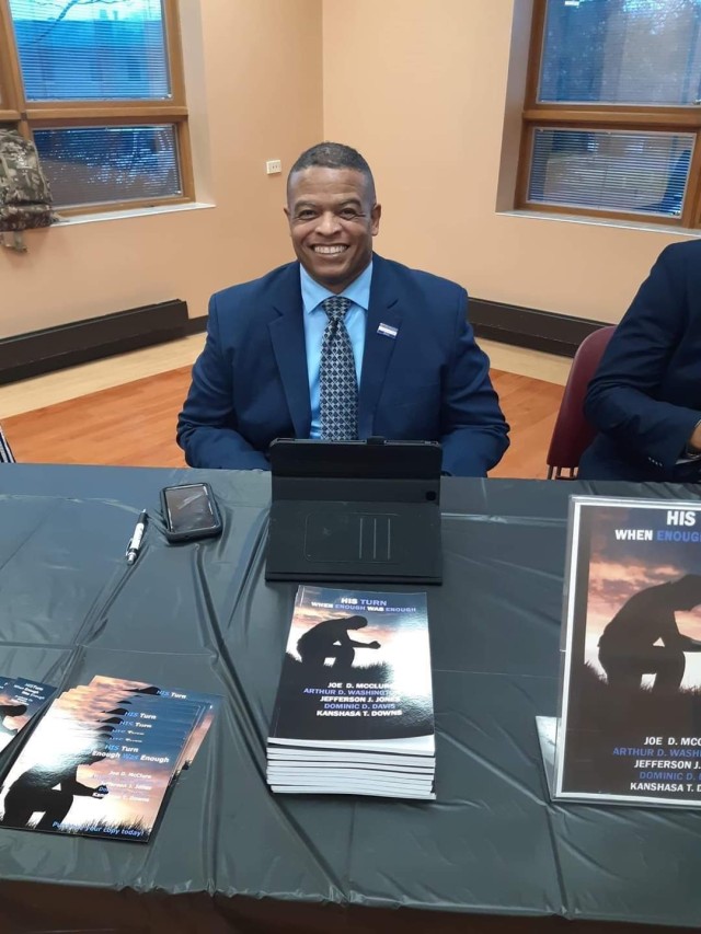 Sgt. 1st Class Arthur Washington of First Army Division West’s 120th Infantry Brigade sits with copies of His Turn: When Enough was Enough during a book signing.