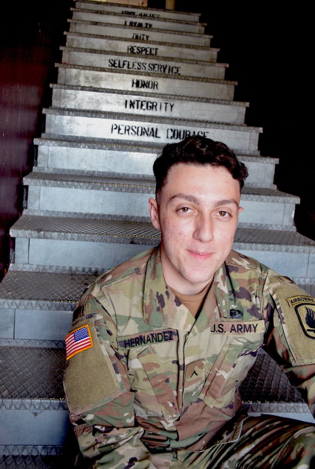 Pvt. Noah Hernandez, the most junior Soldier in Vicenza, poses for a picture inside a motor pool on Caserma Ederle, Vicenza, June 10, 2020. The Seven Army Values stand out on the steps behind him. Hernandez joined the Army in early 2019 and completed basic training at Fort Jackson, SC. He arrived at the 173rd Infantry Brigade Combat Team (Airborne) in January. He currently serves as a computer/detection systems repairer with 1st Battalion, 503rd Infantry Regiment.