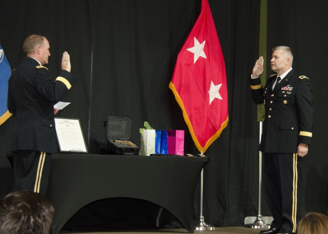 Robert Barrie, deputy program executive officer for aviation, right, recites the oath of office, administered by Maj. Gen. Thomas Todd, during a ceremony to promote him to brigadier general.