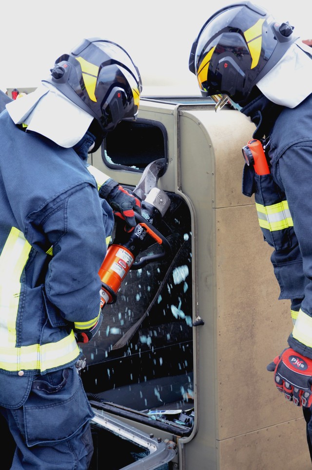 Two firefighters from USAG Italy DES use a hydraulic cutter during one of the extrication exercises on Caserma Ederle June 10, 2020. This type of hands-on training is conducted multiple times each year to give the opportunity for firefighters to respond to a simulated vehicle accident in conjunction with the military police patrols.