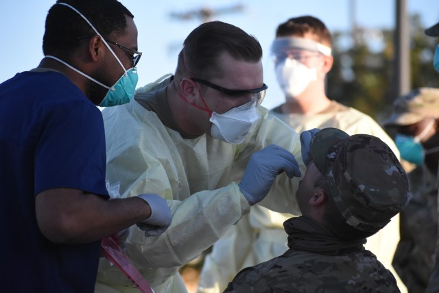 Staff Sgt. Zachary Elenchin of 1st Armored Division, Combat Aviation Brigade, actively conducts a nasal swab test on an E/501st Soldier to ensure his medical readiness.