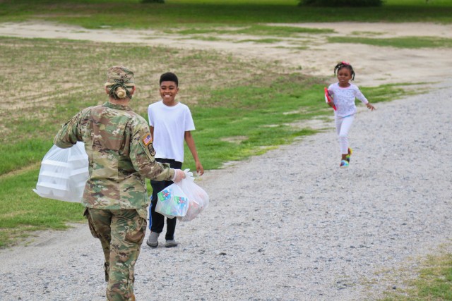 Spc. Amber Cohen, assigned to the 449th Theatre Aviation Brigade, distributes meals, prepared at the ElizabethTown Middle School, to the citizens in Bladen County, N.C., May 26, 2020. The NCNG is working with North Carolina Emergency Management, N.C. Department of Health and Human Services and local food banks to help support COVID-19 relief efforts. (U.S. Army National Guard photo by Spc. Hannah Tarkelly, 382nd Public Affairs Detachment/Released).
