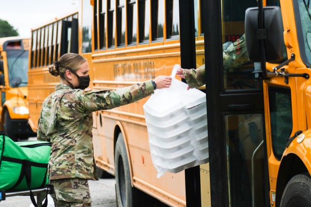 Spc. Dunn, assigned to the 449th Theatre Aviation Brigade, loads meals onto a school bus to distribute to the citizens of Bladen County at the Elizabethtown Middle School in Bladen County, N.C., May 26, 2020. The NCNG is working with North Carolina Emergency Management, N.C. Department of Health and Human Services and local food banks to help support COVID-19 relief efforts. (U.S. Army National Guard photo by Spc. Hannah Tarkelly, 382nd Public Affairs Detachment/Released).